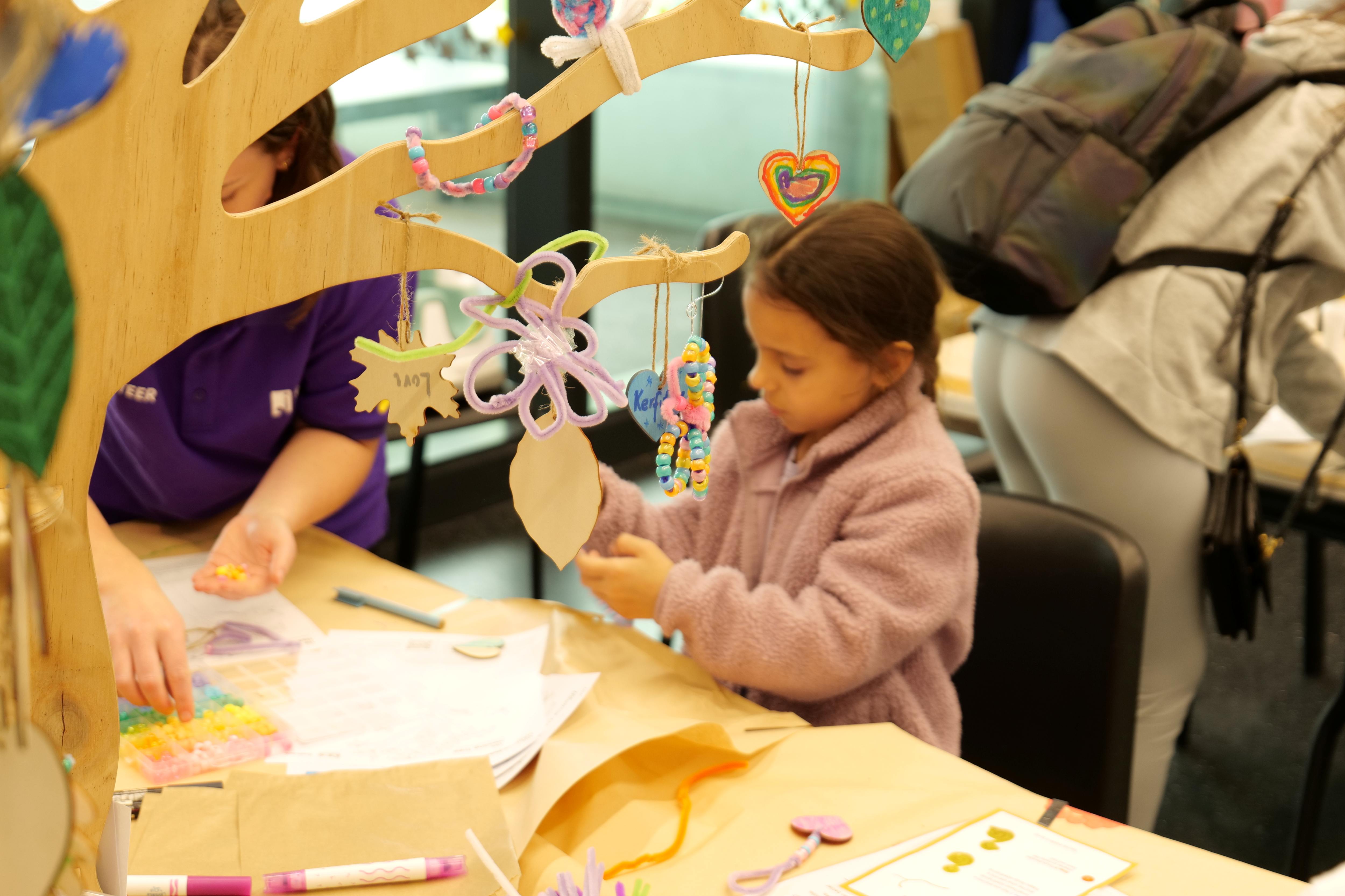A young girl doing a creative activity next to the Healing Tree